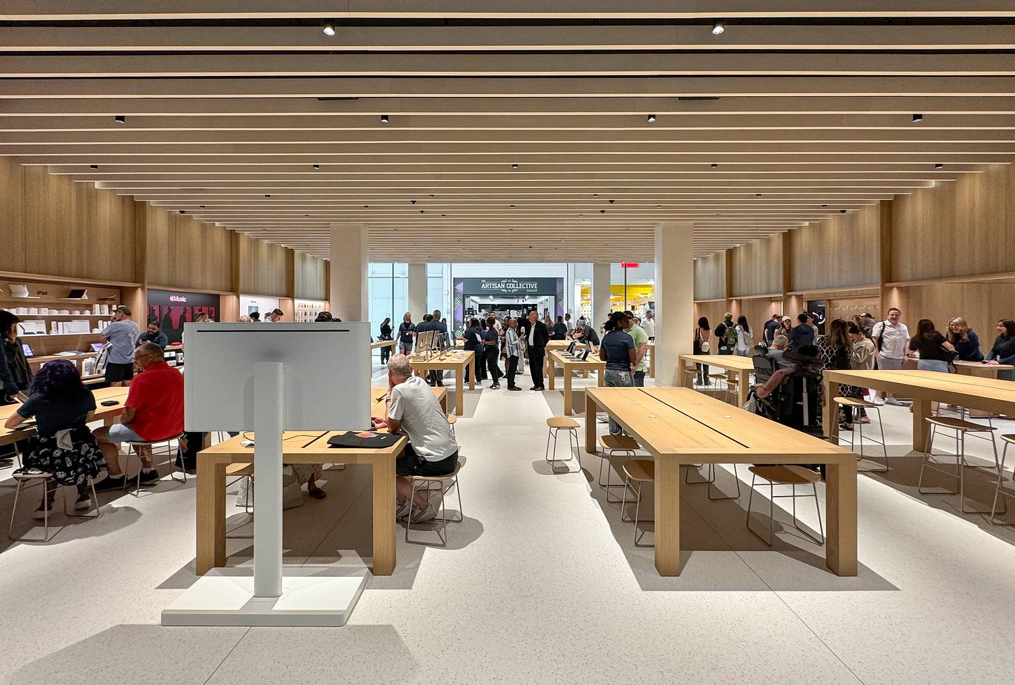 The interior of Apple Milton Keynes as photographed from the back of the store. A Today at Apple display is at the left side of the frame.