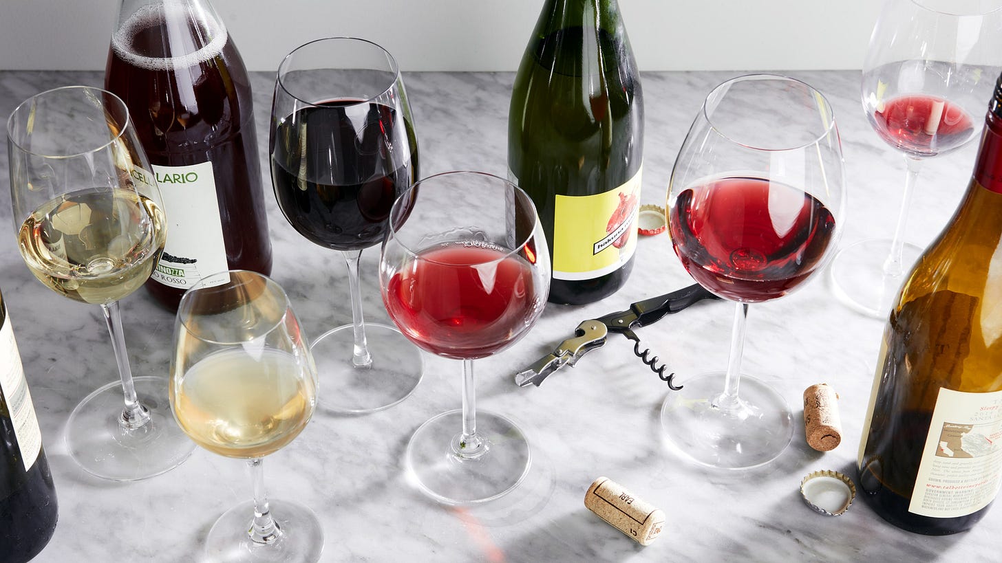 Photo of a collection of the best wine glasses with several bottles of wine.