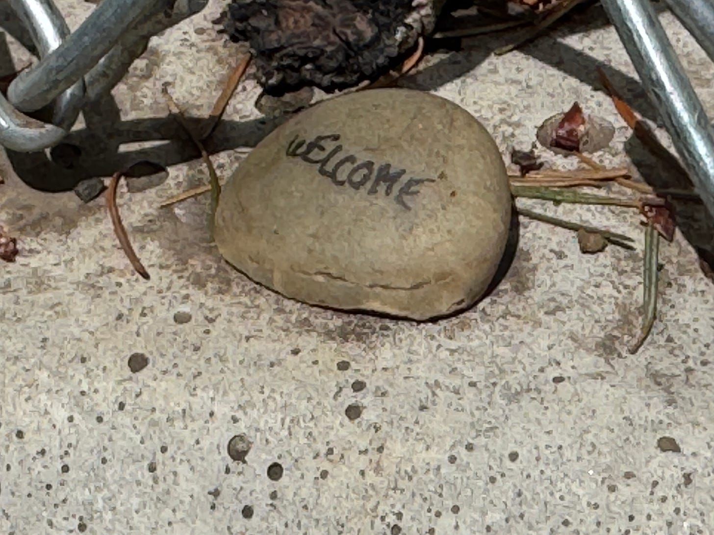 A rock. Someone has written, "welcome."