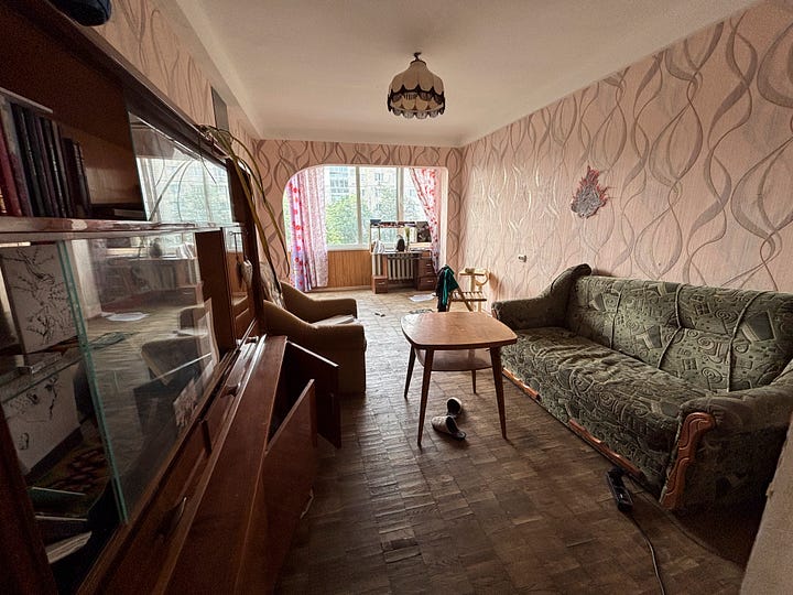 Inside the quiet refuge offered by Daniya, a flat suspended in Soviet time, every object became a gesture of resistance. A kitchen table, modestly dressed in a floral cloth, bore the soft weight of microgreens, tea cups, and conversation. The corridor, narrow and unremarkable by design, transformed into a sanctuary as mattresses were unrolled beneath pale yellow walls. The living room, with its tired green sofa and curtains parting just slightly to the outside world, stood as both a relic and a witness. Here, in a home untouched by shrapnel but not by fear, we lived through the night not by fleeing, but by choosing where to lie down. In Kyiv, safety isn’t found in bunkers. It’s made by people who keep the kettle warm and the blankets near the hallway.