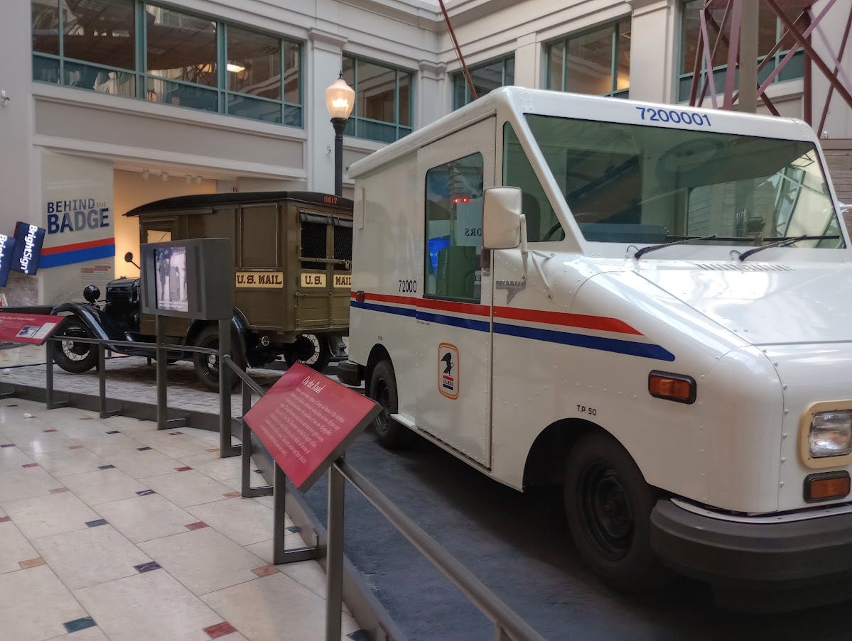 Modern mail truck, and early 20th century mail truck, back to back Modern mail truck, and early 20th century mail truck, back to back