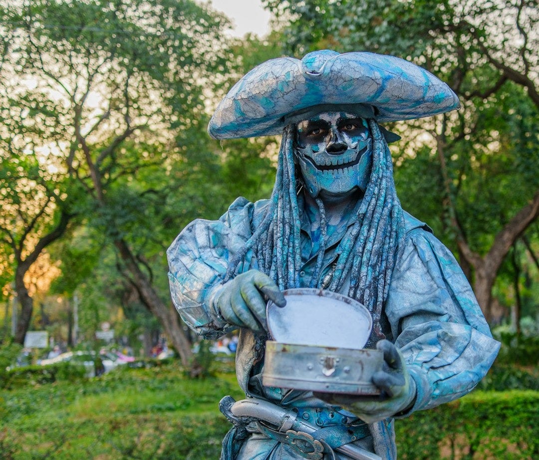 a statue of a man dressed in blue and wearing a hat