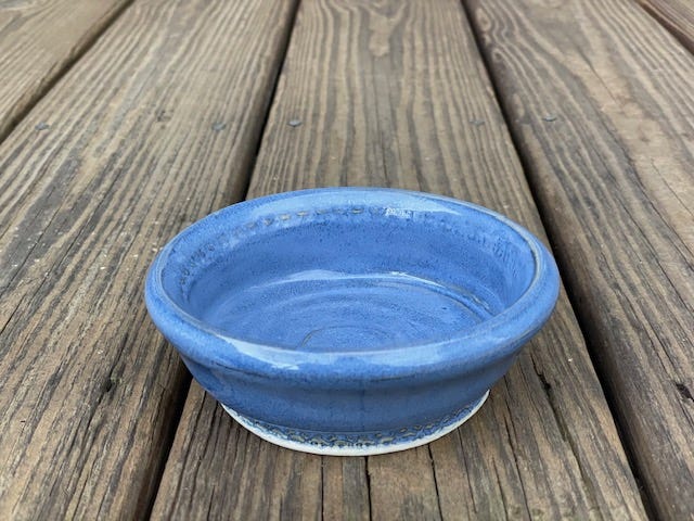 woman at pottery wheel making bowl; completed bowl