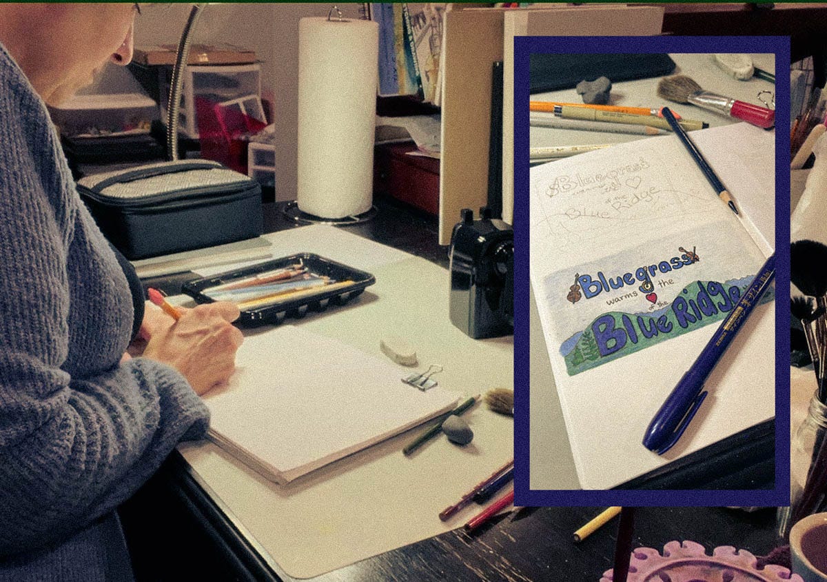 A woman sits at a cluttered art desk sketching in a notebook, surrounded by pencils and brushes. Beside her, an inset photo shows a colored drawing that reads “Bluegrass warms the Blue Ridge” with mountains and instruments.