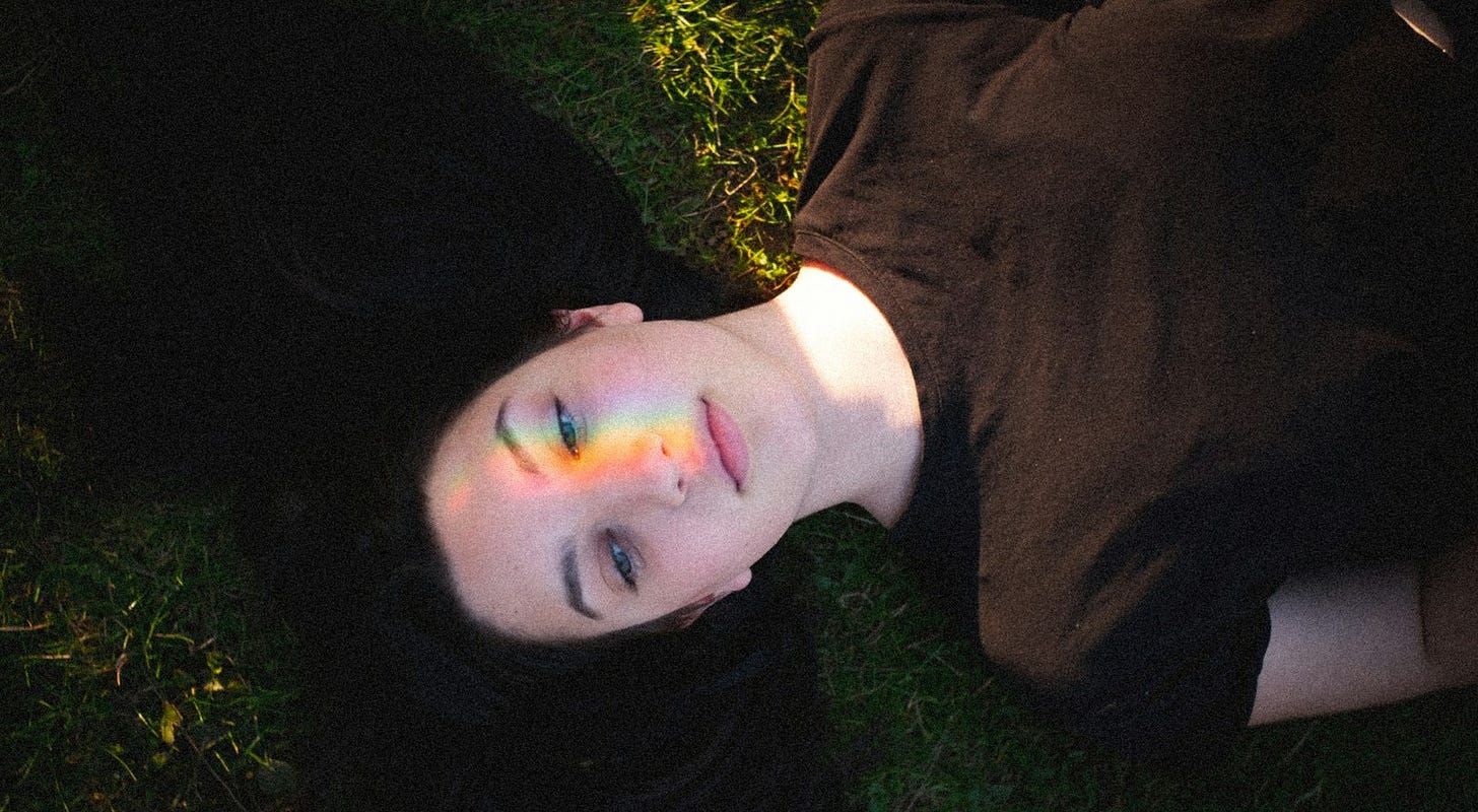 woman in black crew neck shirt lying on green grass woman in black crew neck shirt lying on green grass