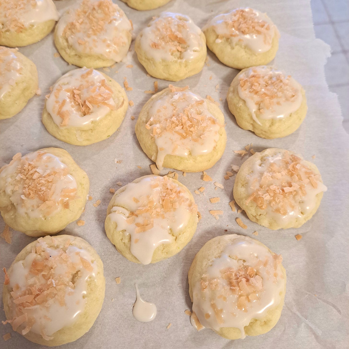 Coconut Lime cookies lay on a sheet of parchment paper.