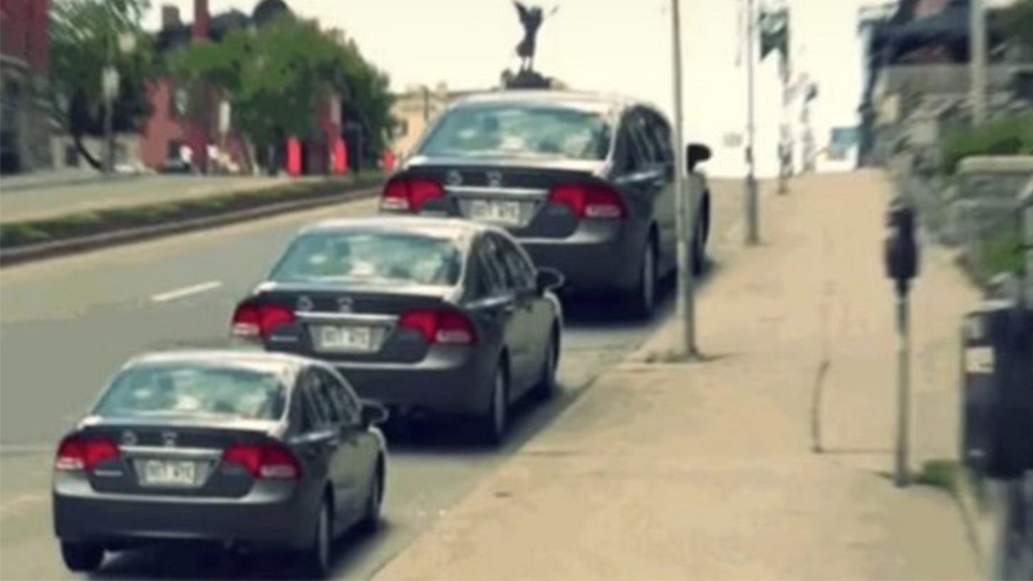 Three cars driving up a hill (or being parked)