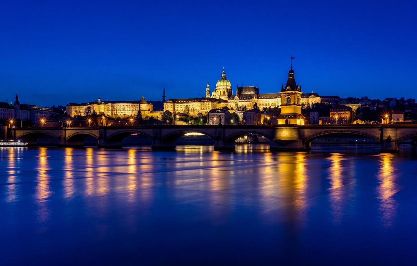Prague Charles Bridge and castle skyline at blue hour over the Vltava