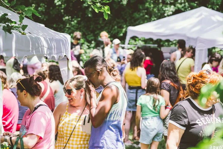 The image depicts a lively outdoor gathering under a tent, with people engaged in conversation and activities amidst a green, leafy backdrop.
AI-generated content may be incorrect. The image depicts a lively outdoor gathering under a tent, with people engaged in conversation and activities amidst a green, leafy backdrop.
AI-generated content may be incorrect.
