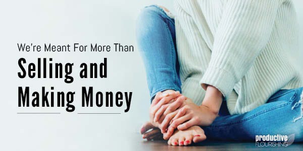 Person in a white sweater and jeans sitting on the ground. Text overlay: We're Meant For More Than Selling and Making Money Person in a white sweater and jeans sitting on the ground. Text overlay: We're Meant For More Than Selling and Making Money