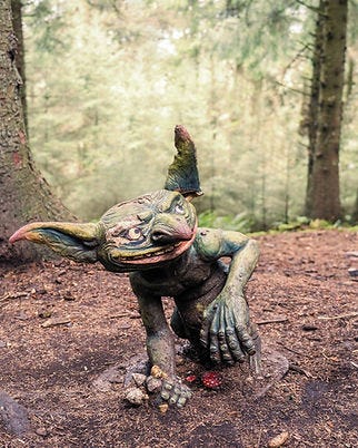 A sculpture of a small, green creature with long ears and a wide grin. A sculpture of a small, green creature with long ears and a wide grin.
