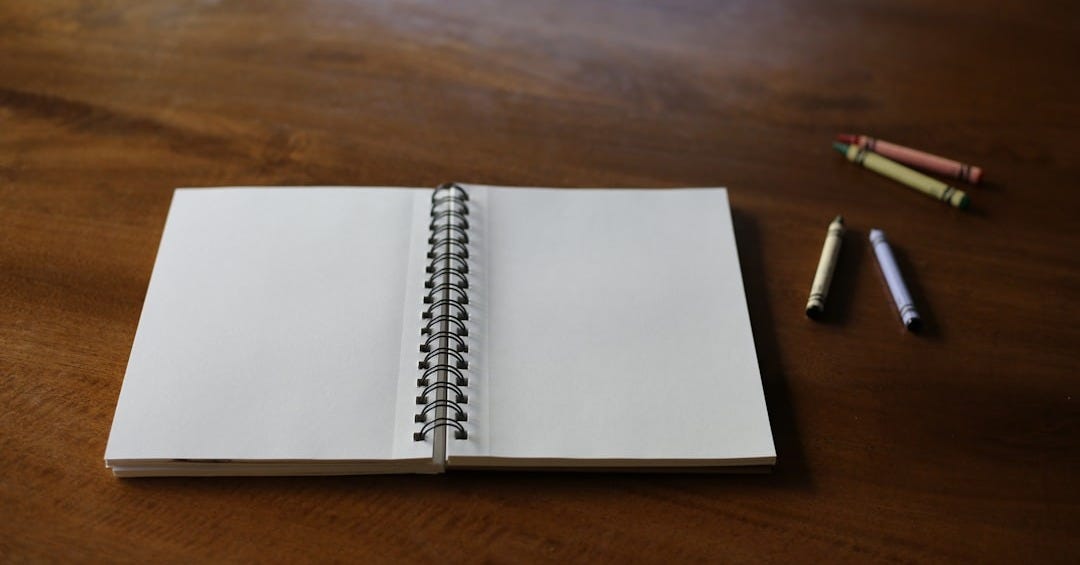 A notebook with a pen on a wooden table