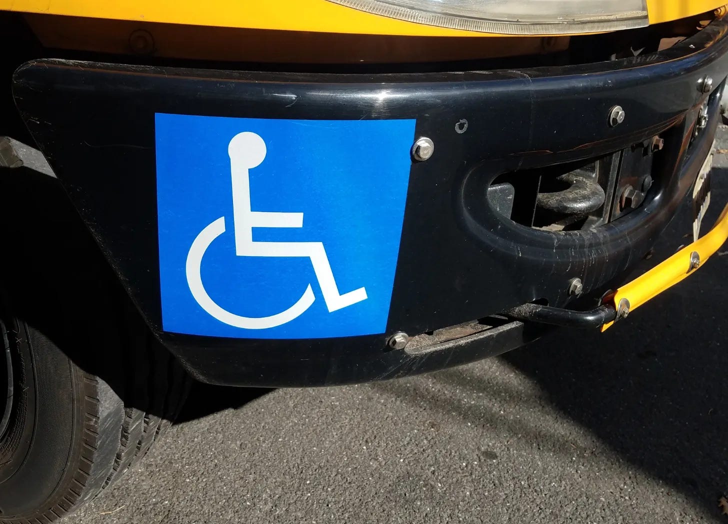 Wheelchair symbol sticker on a car bumper on a car bumper