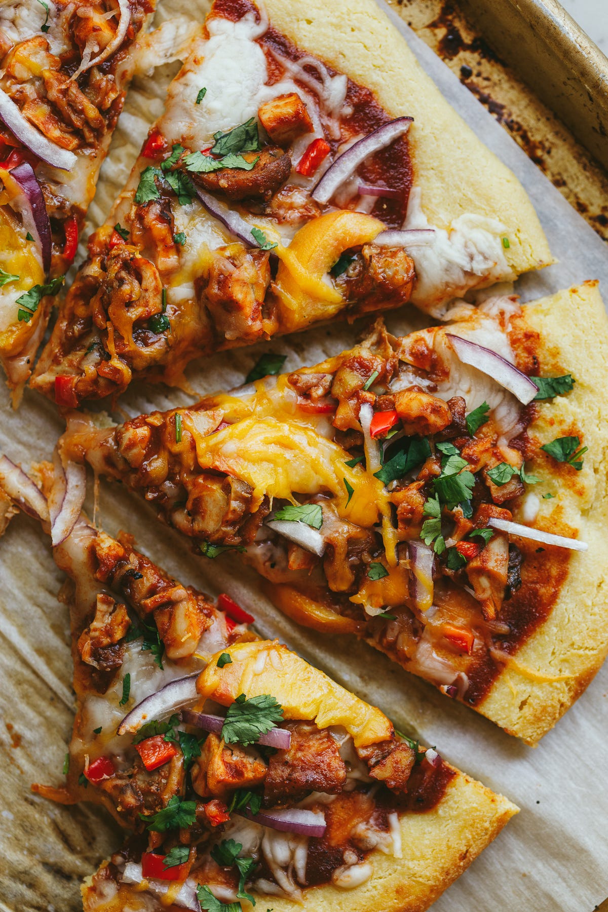 BBQ chicken flatbread slices on a sheet pan.