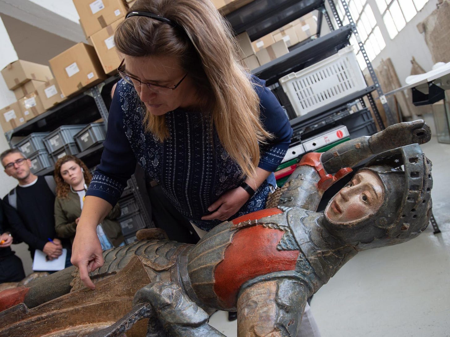 Conservators examining the wooden sculpture of Saint George after its professional restoration in Estella, Spain Conservators examining the wooden sculpture of Saint George after its professional restoration in Estella, Spain