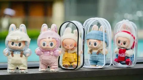 Xia Yu/VCG via Getty Images Five Labubu dolls, in plastic cases, stand in a line Xia Yu/VCG via Getty Images Five Labubu dolls, in plastic cases, stand in a line
