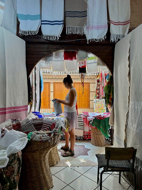 an image of a man weaving a red rug, a picture of me talking to the lady from Valencia about the rugs in warehouse, a picture of a the white rooftop at maison maggie with a red stripe rug and green stripe bench