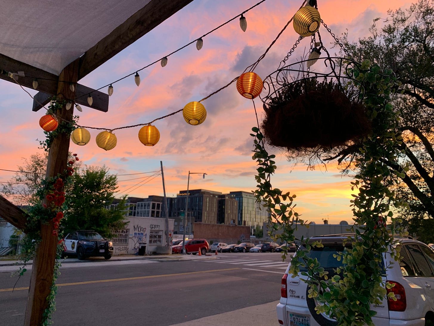 View of the sunset from the Songbyrd Music House patio. You can see a string of lanterns.