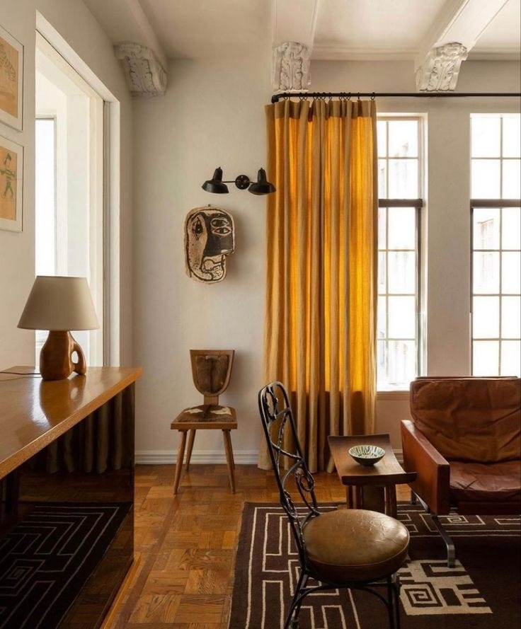 This may contain: a living room filled with furniture next to a window covered in yellow drapes and curtains