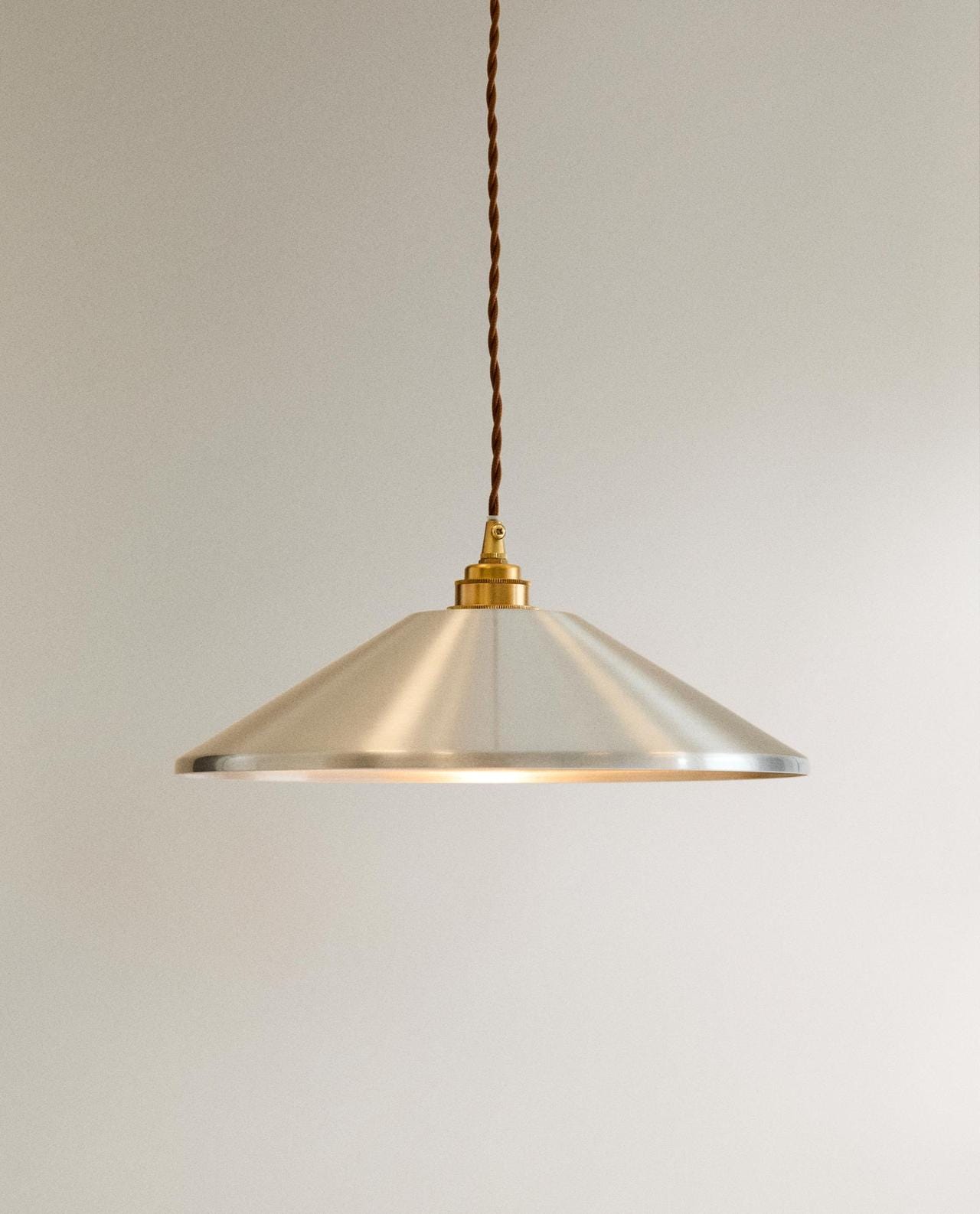 Grey pendant light with conical metal shade and brown braided cable. Grey pendant light with conical metal shade and brown braided cable.
