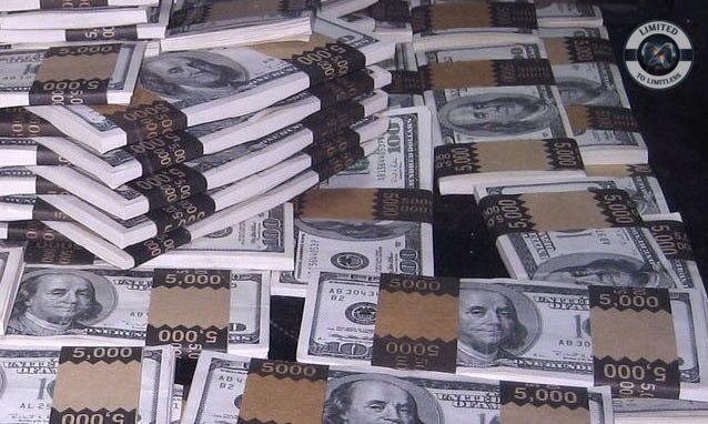 a pile of US dollars with $5000 bands on them