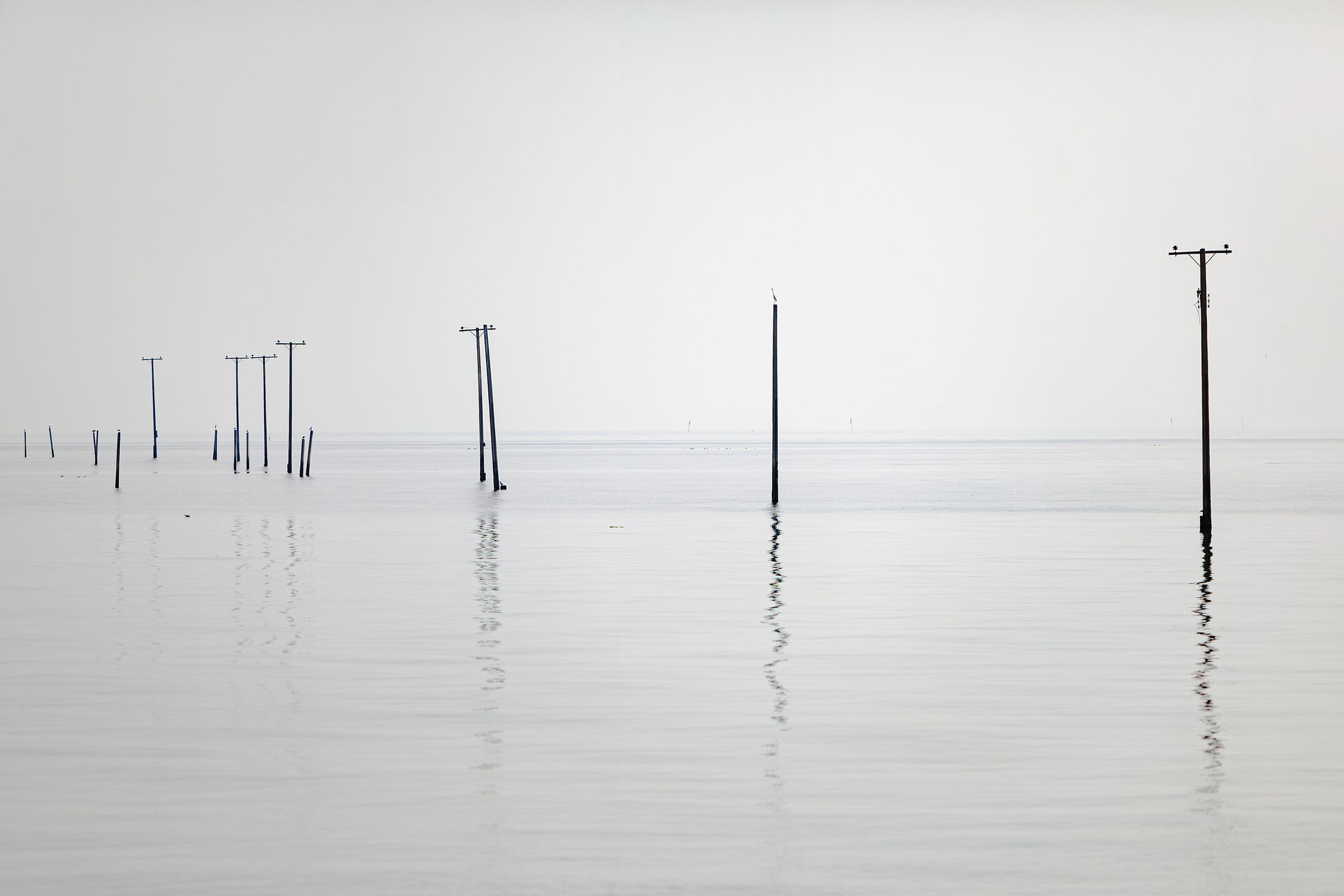 Telegraph poles mark the location of sunken homes at Ban Khun Samut Chin, Thailand. © Gavin Gough