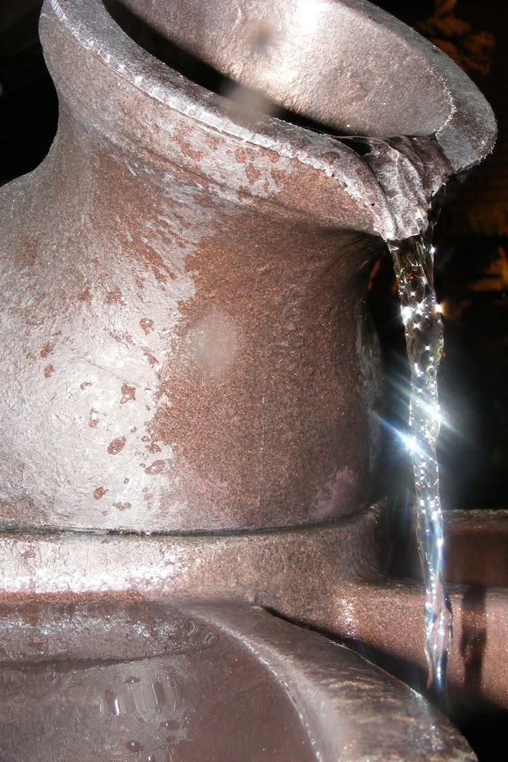 This may contain: a close up of a metal object with water coming out of it