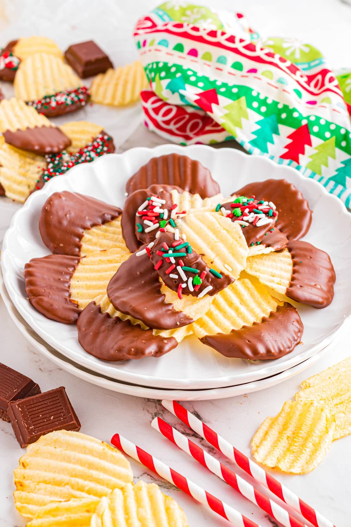 Chocolate covered potato chips on a scalloped plate on festive table. Chocolate covered potato chips on a scalloped plate on festive table.