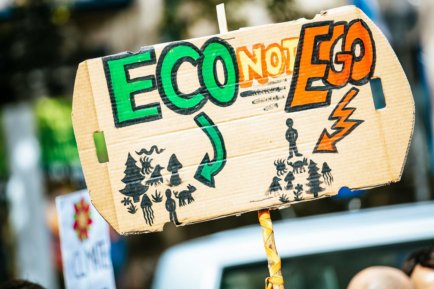 Cardboard sign with "ECO NOT EGO" and nature vs. industrial illustrations. Cardboard sign with "ECO NOT EGO" and nature vs. industrial illustrations.