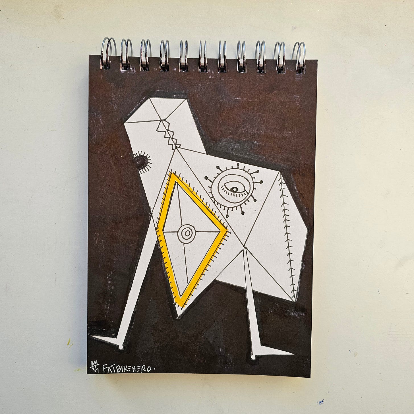  A high-contrast geometric drawing by artist FatbikeHero (b. 1983). The image depicts an angular, white bird-like figure with a singular, radiating eye and a yellow triangle breastplate, set against a dark painted background. The figure features stitch-like markings, suggesting an artificial or constructed nature.