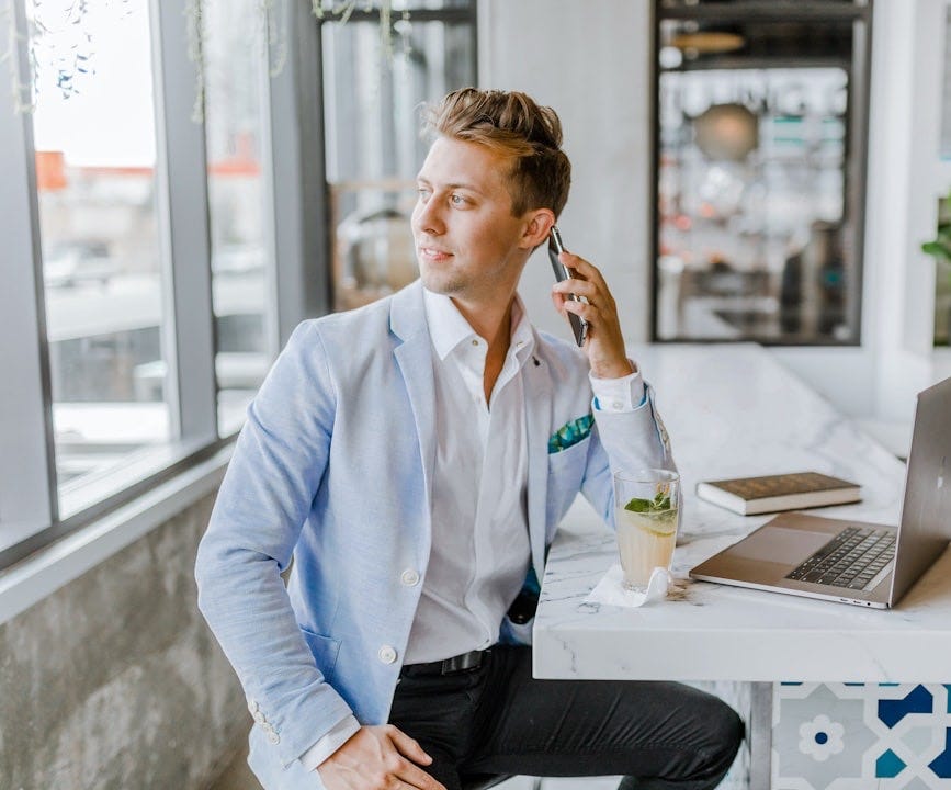 man sitting beside white wooden table man sitting beside white wooden table