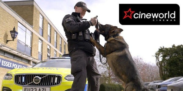 Special Constable volunteer working with a police dog next to a police car outside the Essex Police College. Cineworld logo in top right corner