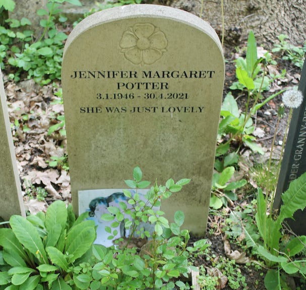 Headstone with plants and a photo tucked next to it. Reads: "Jennifer Margaret Potter / 3.1.1946 - 30.4.2021 / She was just lovely"