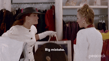 GIF of Julia Roberts as Vivian Ward in Pretty Woman carrying multiple shopping bags on Rodeo Drive, representing the thrill of a successful beauty haul.