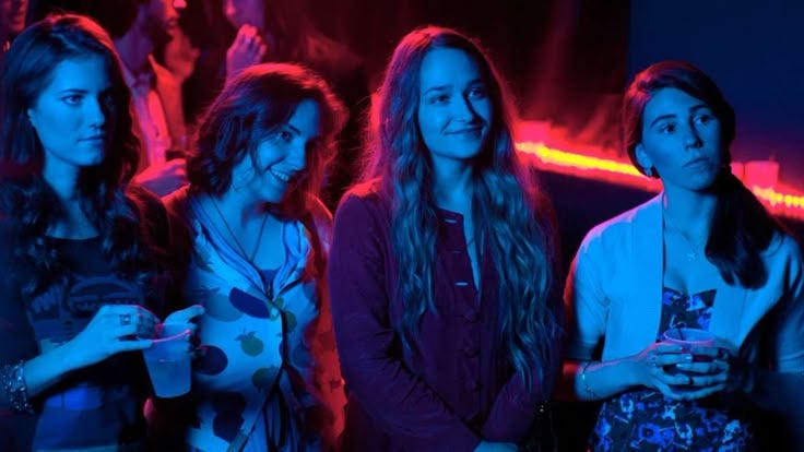 This may contain: three girls are standing together in the dark