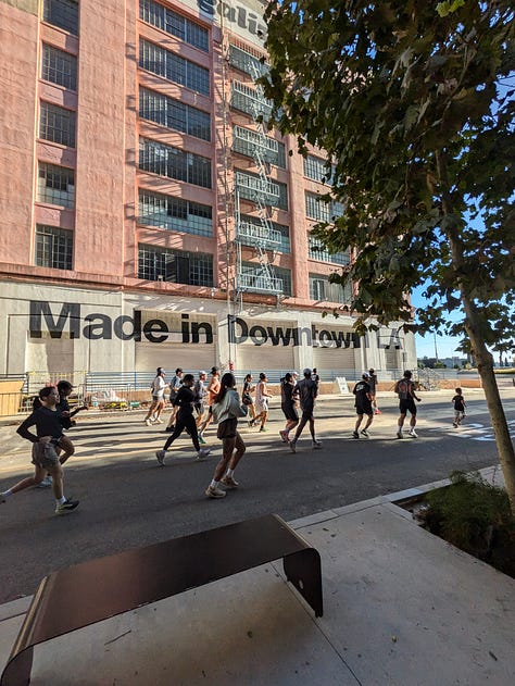 A photo of people running across the 6th St Bridge, past the old American Apparel building, and my tshirt saying EAT PASTA RUN FASTA