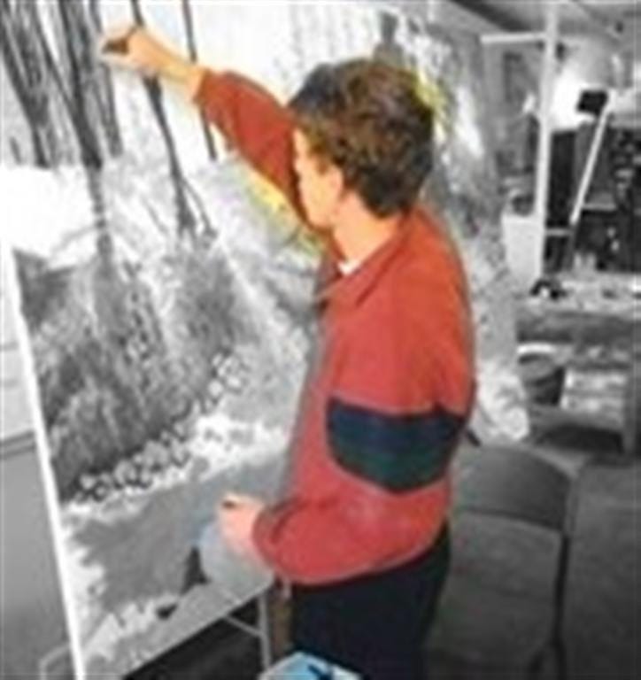 A black and white photograph of a young Michal Plis at age 16, standing in profile while working on a large canvas on an easel in an art studio. A black and white photograph of a young Michal Plis at age 16, standing in profile while working on a large canvas on an easel in an art studio.