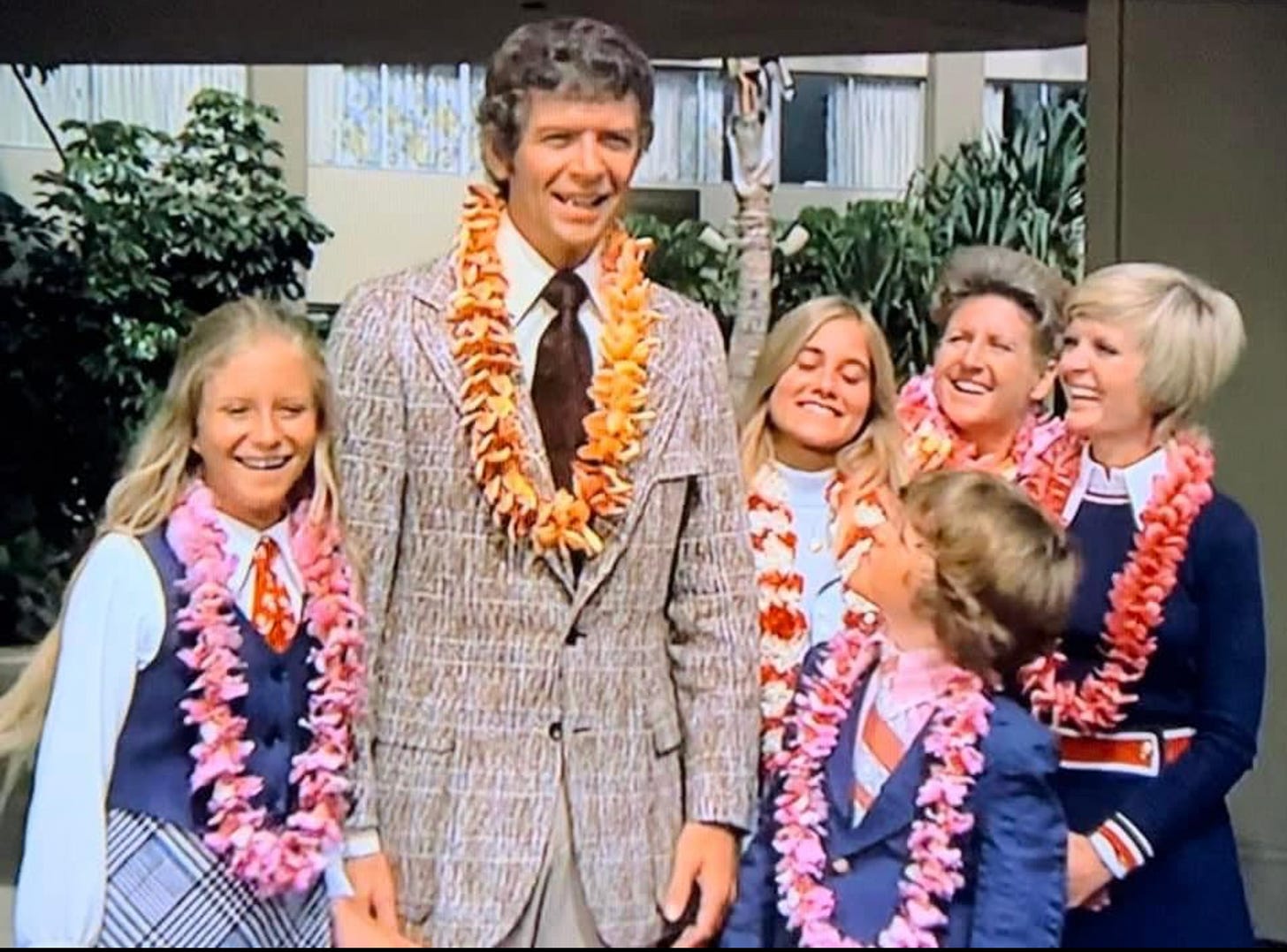 Bradys in leis and three piece suits looking like total dorks. 