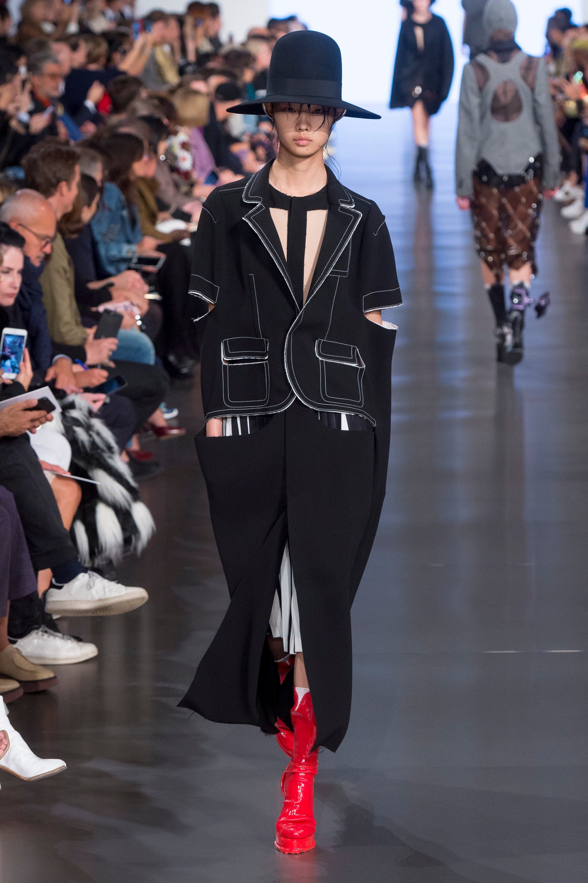 Image may contain Footwear Clothing Shoe Apparel Hat Human Person Female Runway Woman Suit Coat and Overcoat