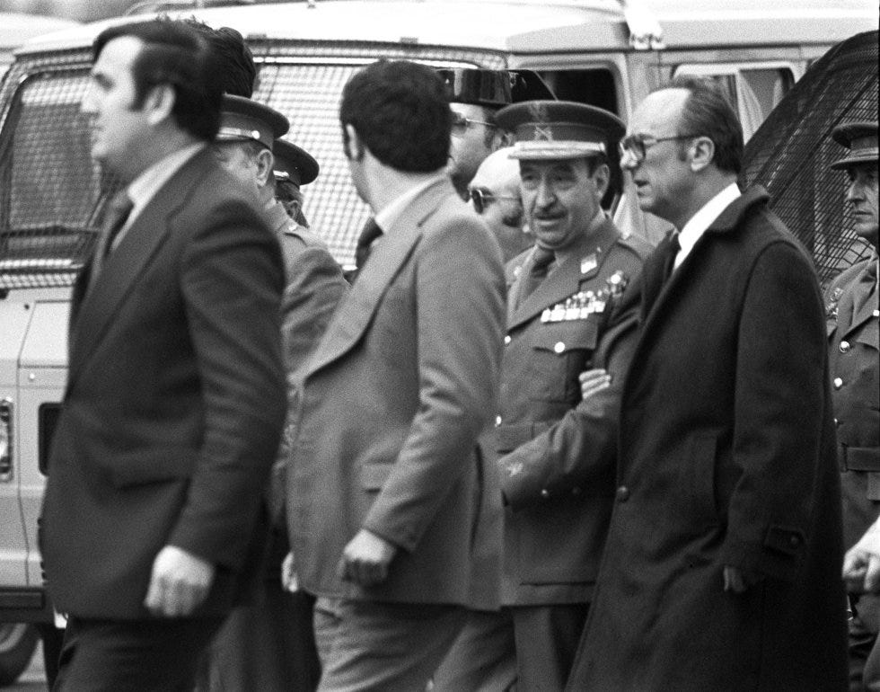 El general Alfonso Armada sale acompañado por el gobernador civil de Madrid Mariano Nicolás García, a la derecha, del Congreso de los Diputados tras fracasar el 23-F. Armada, que era el segundo jefe del Estado Mayor del Ejército cuando se produjo el intento de golpe y hombre de confianza del rey Juan Carlos (y del que Adolfo Suárez desconfiaba) fue uno de sus principales protagonistas y para muchos el arquitecto del 23-F. Se ha especulado mucho sobre el papel de Armada y en consecuencia sobre el papel del Rey. Rozando la medianoche, Armada entró en el Congreso para negociar con Tejero, al que le habría propuesto un Gobierno de concentración nacional formado por militares y civiles. Algo que Tejero habría rechazado. Fue acusado por otros participantes en el golpe de mentir en el juicio que tuvo lugar un año después. Condenado a seis años de cárcel (y posteriormente a 30), cinco años después fue indultado por el Gobierno de Felipe González, por razones de salud. Murió en su pazo de A Coruña con 93 años.