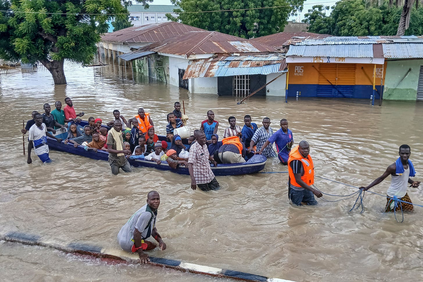 People affected by floods are escorted through flood water on a military boat in Maiduguri, the capital of Borno State in the Lake Chad region of Nigeria, last year