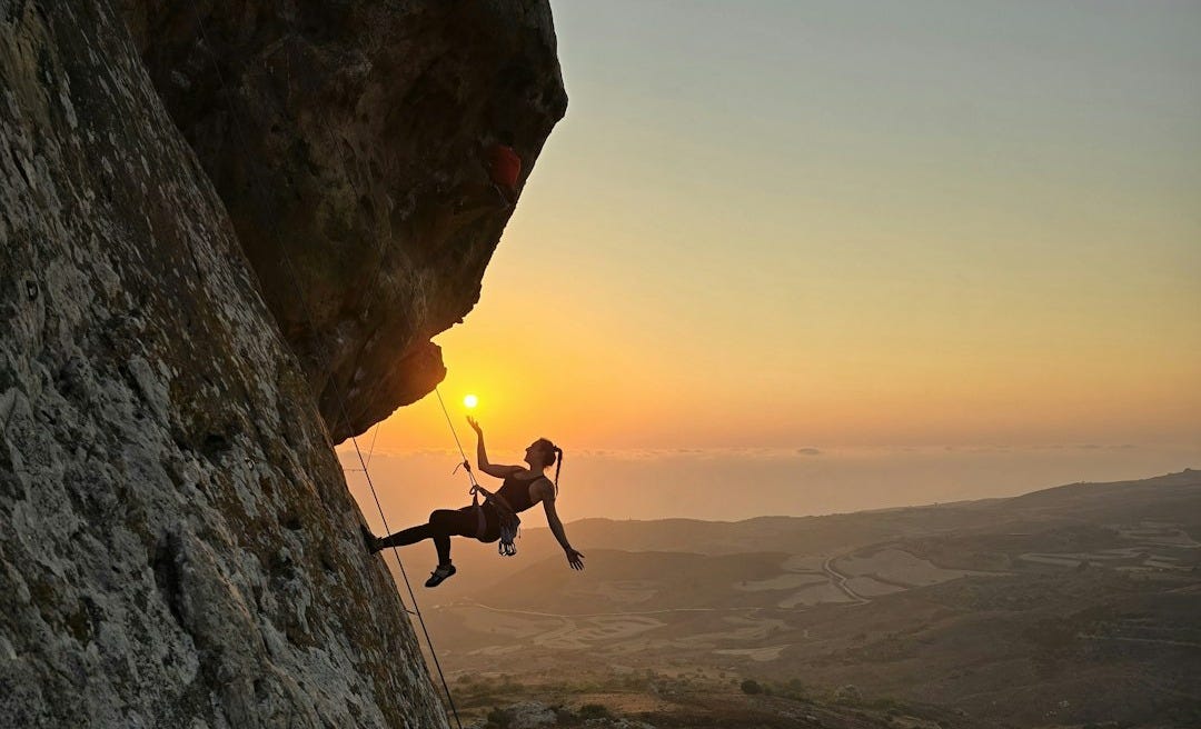 A man climbing up the side of a mountain A man climbing up the side of a mountain