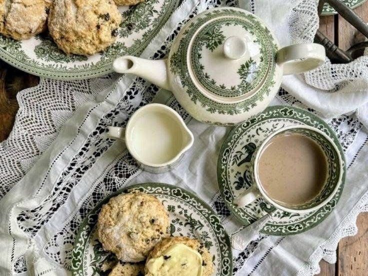 This may contain: two plates with cookies on them next to cups and saucers