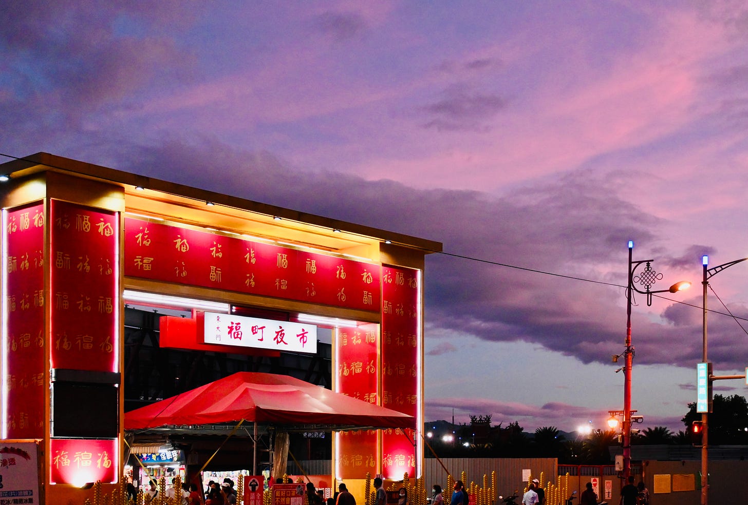 A spectacular sunset turns the clouds purple above the massive red gate to Dongdamen 東大門 night market in Hualien 花蓮, Taiwan A spectacular sunset turns the clouds purple above the massive red gate to Dongdamen 東大門 night market in Hualien 花蓮, Taiwan