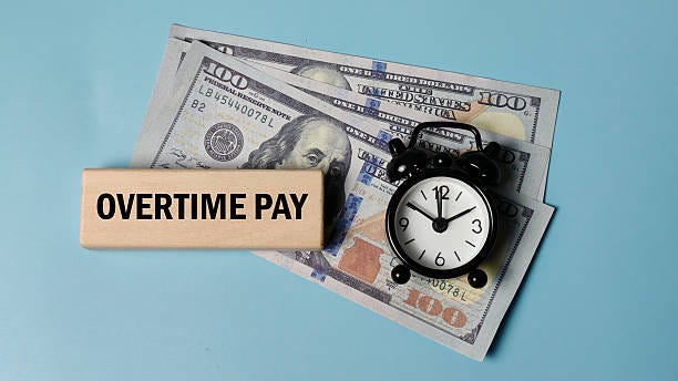 Concept of Overtime Pay with US dollar bills, a wooden block reading OVERTIME PAY, and an alarm clock, symbolizing extra work compensation and time equals money. Concept of Overtime Pay with US dollar bills, a wooden block reading OVERTIME PAY, and an alarm clock, symbolizing extra work compensation and time equals money. overtime stock pictures, royalty-free photos & images Concept of Overtime Pay with US dollar bills, a wooden block reading OVERTIME PAY, and an alarm clock, symbolizing extra work compensation and time equals money. Concept of Overtime Pay with US dollar bills, a wooden block reading OVERTIME PAY, and an alarm clock, symbolizing extra work compensation and time equals money. overtime stock pictures, royalty-free photos & images