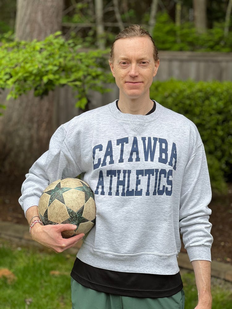 College Application Guy with a soccer ball in a Catawba Athletics sweatshirt