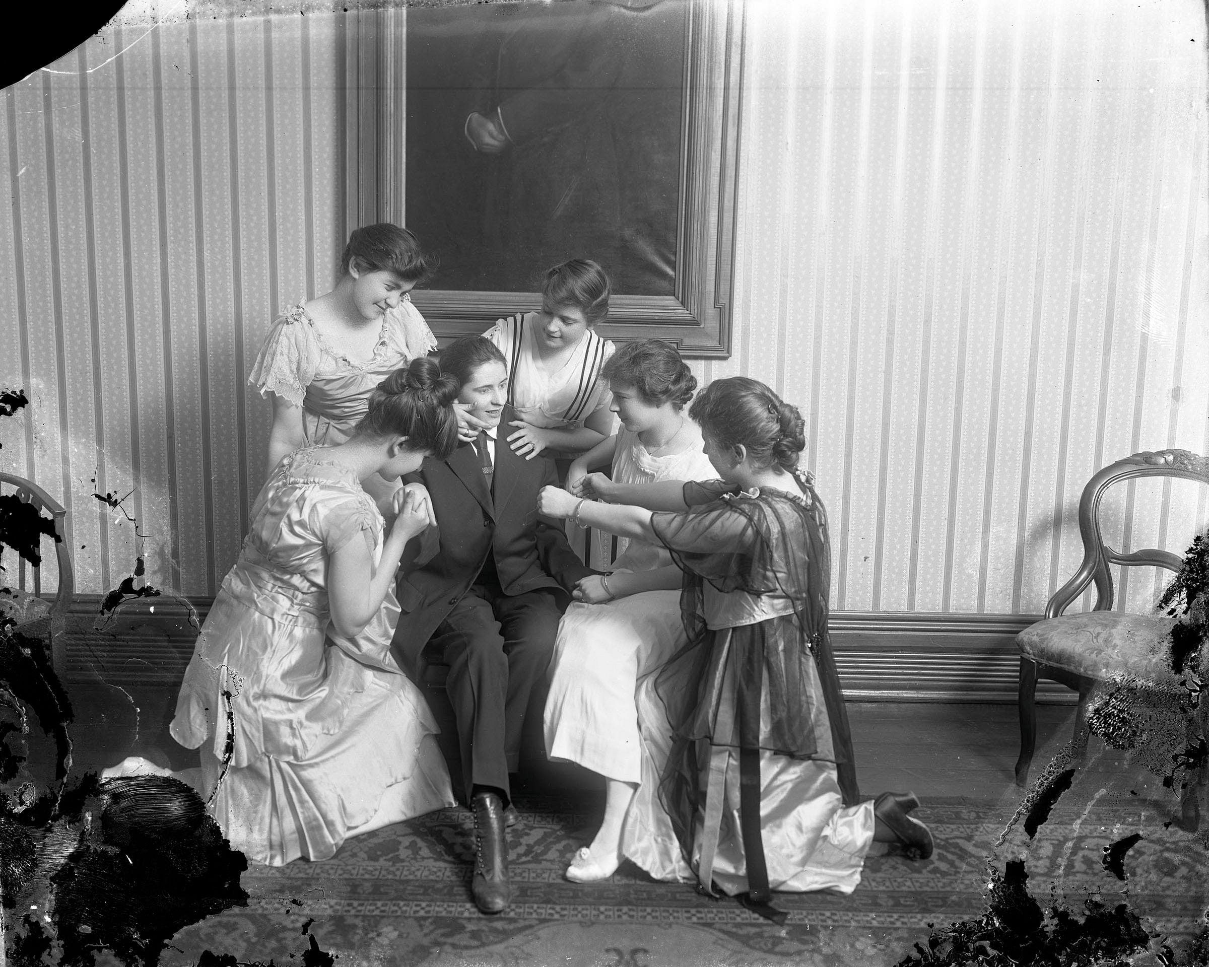 Women around woman in man's suit