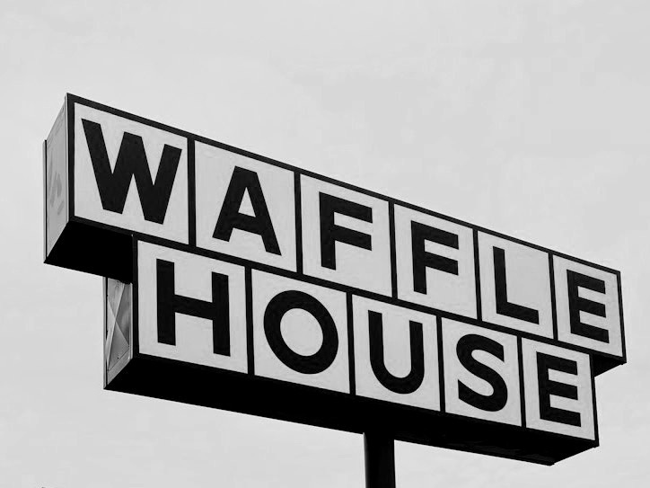 man and woman walking towards Waffle House store