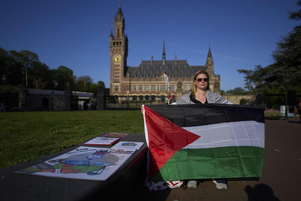 Pro-Palestinian demonstrator next to the ICC (Photo: AP Photo/Peter Dejong) מפגינה פרו פלסטינית מול בית הדין לצדק ב האג הולנד