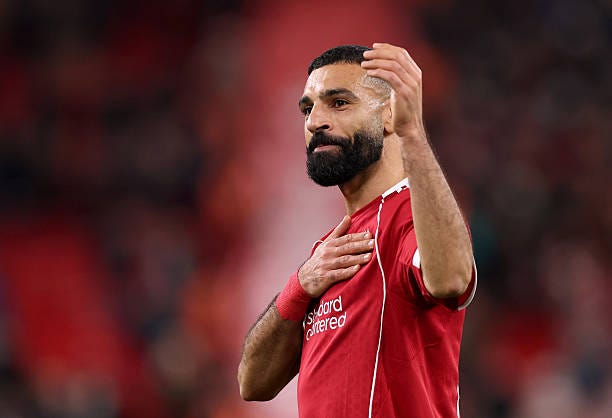 Mohamed Salah of Liverpool acknowledges the fans, whilst patting the Liverpool badge after the Premier League match between Liverpool and Brighton &...